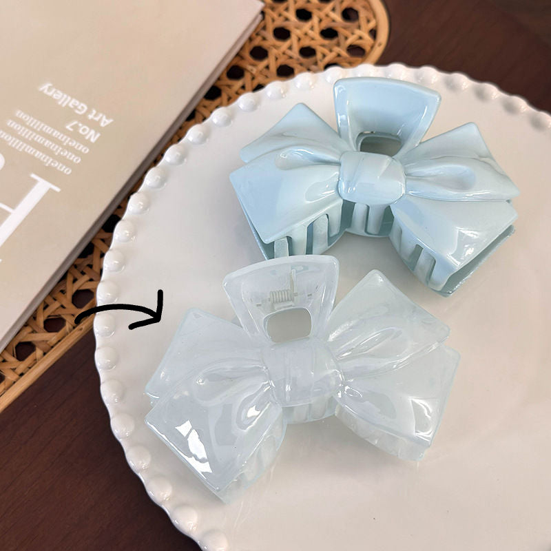 Two light blue bow-shaped items on a white plate with a blurred background