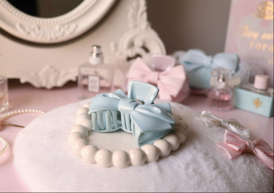 Gray bow hair clip on a textured surface