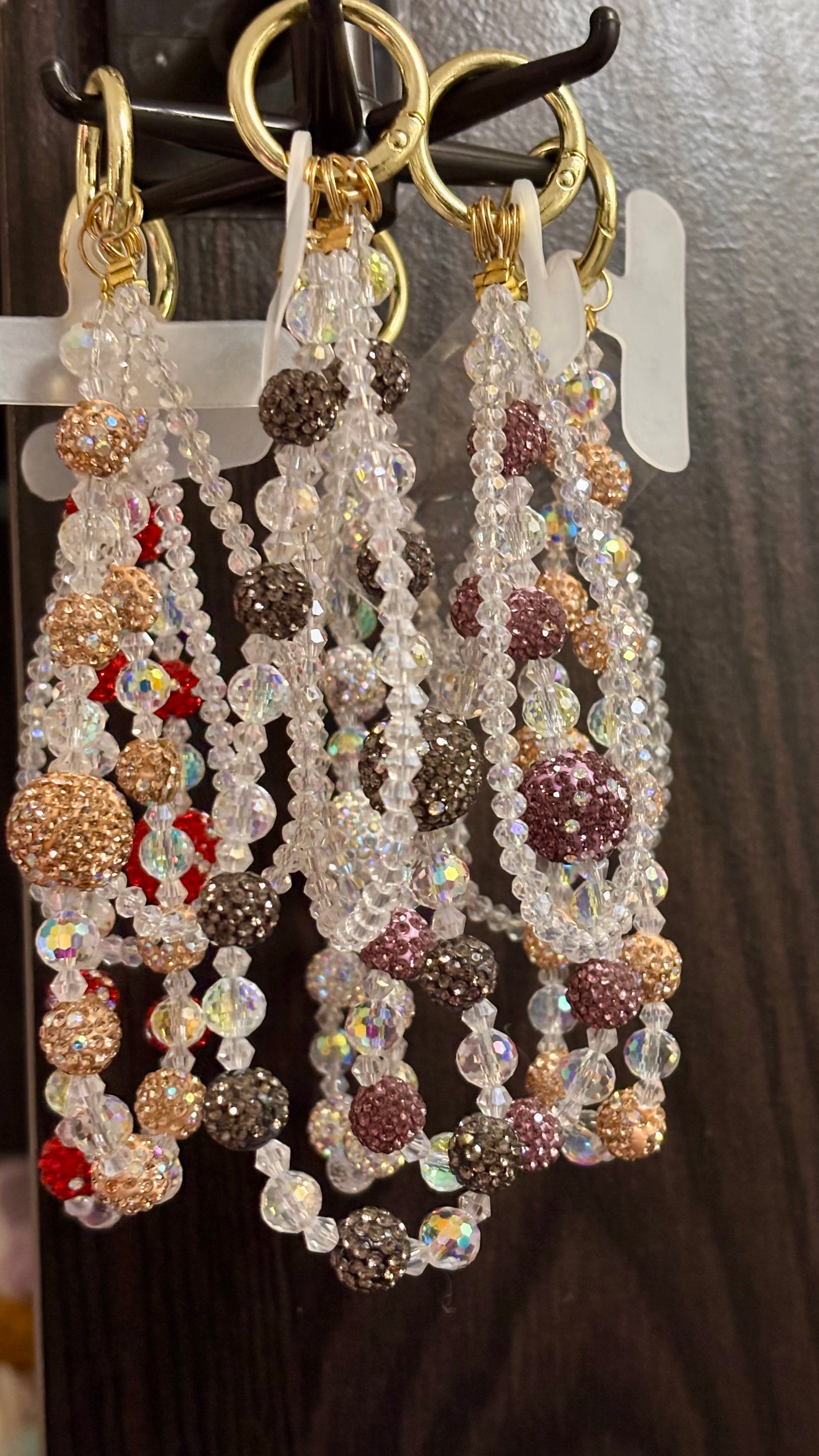 Beaded phone chams with colorful beads on a hook against a dark background