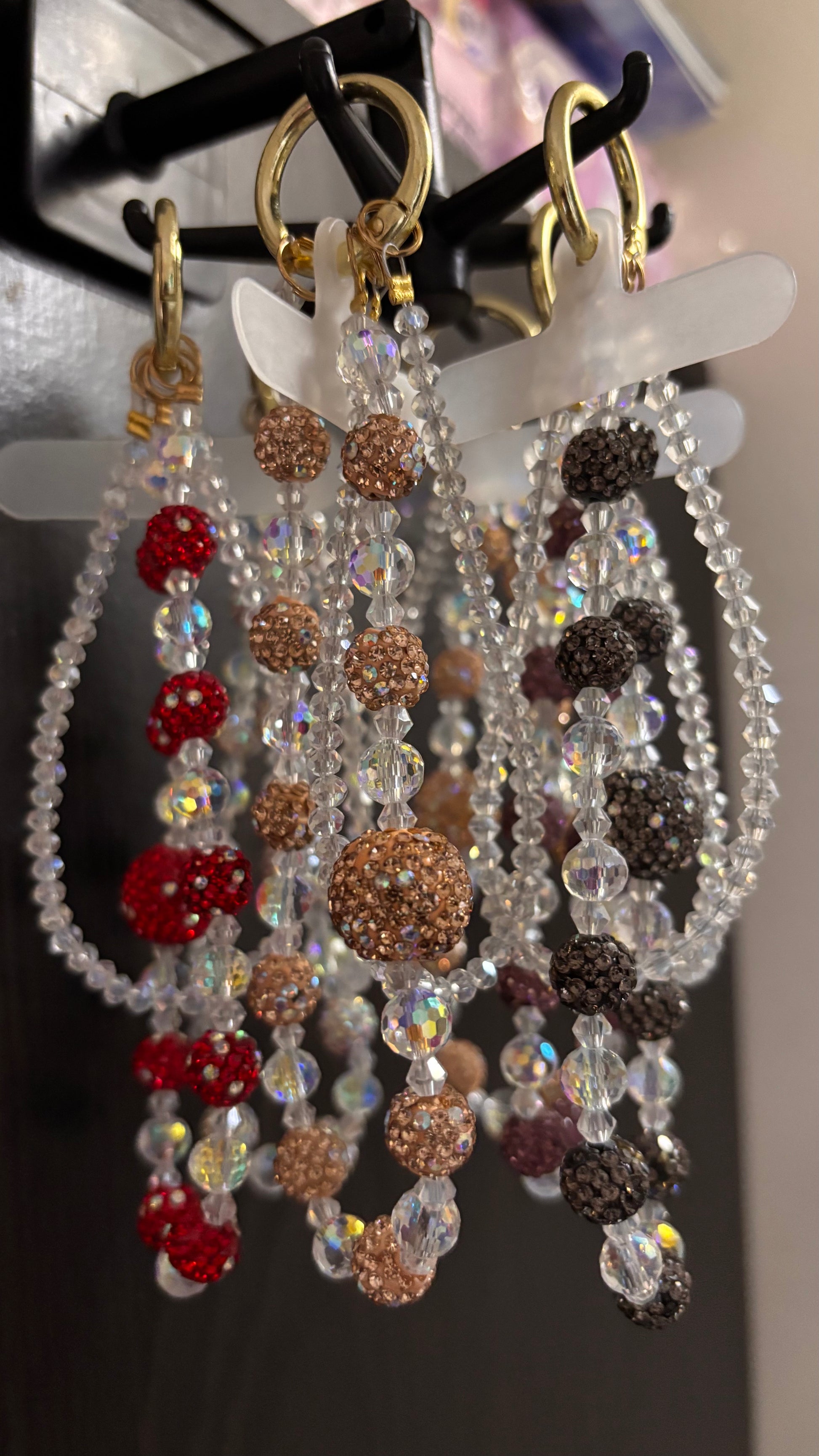 Set of beaded phone charm on a display stand with a blurred background