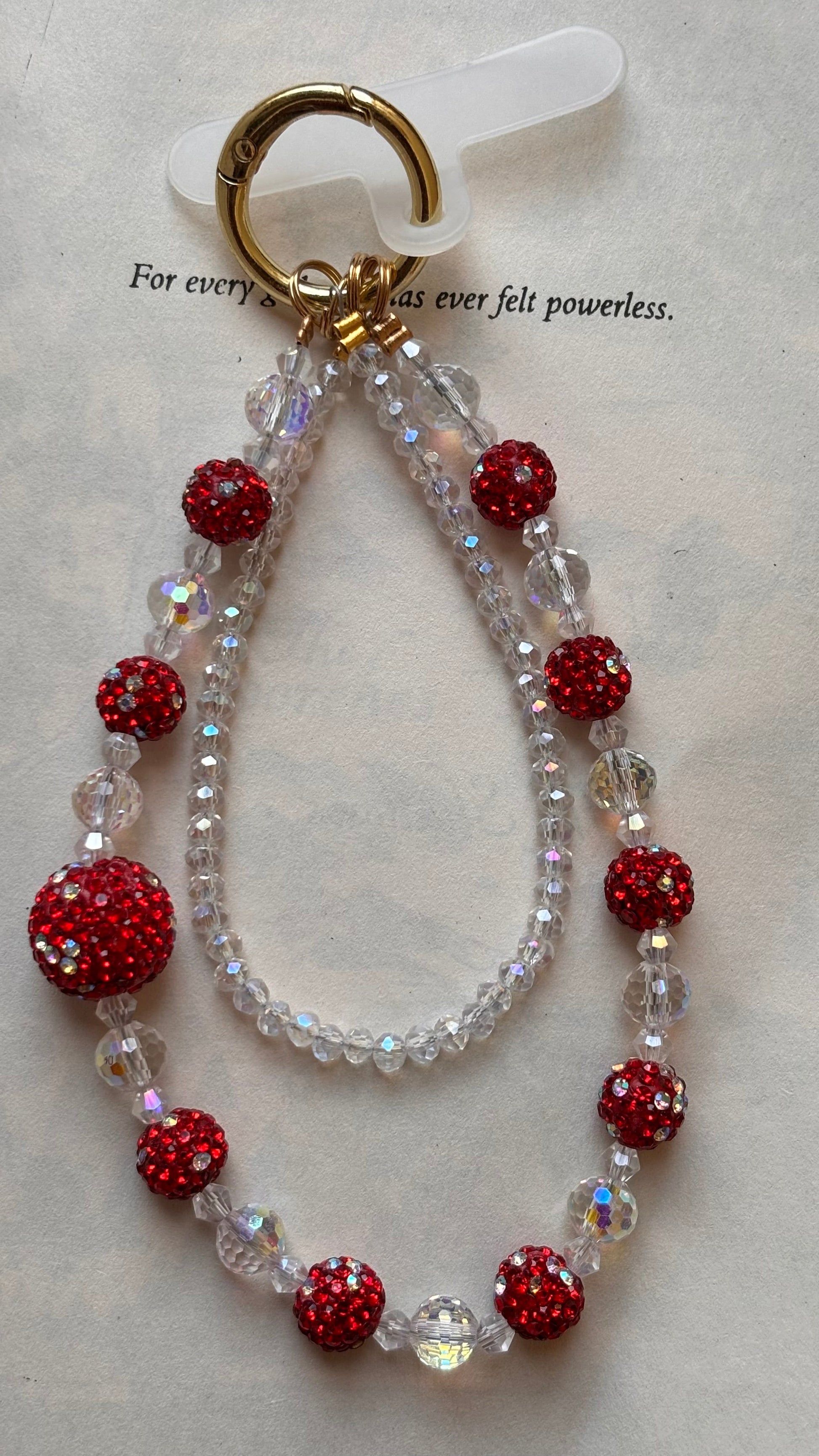 Bracelet with red and clear beads on a beige background