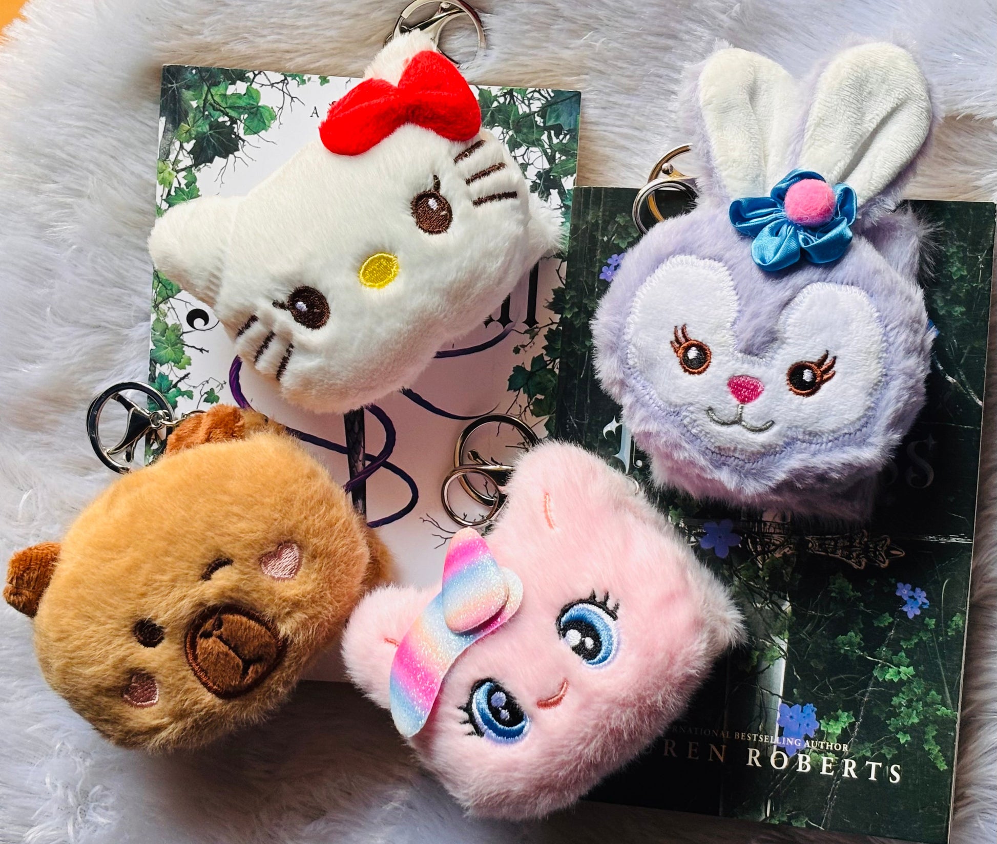 Four plush mirror keychains on a magazine with a white background
