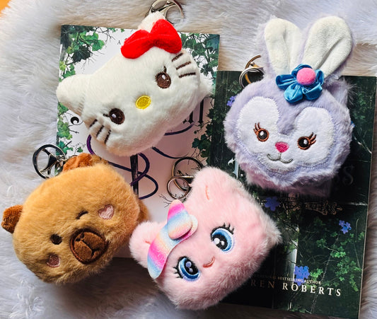 Four plush mirror keychains on a magazine with a white background