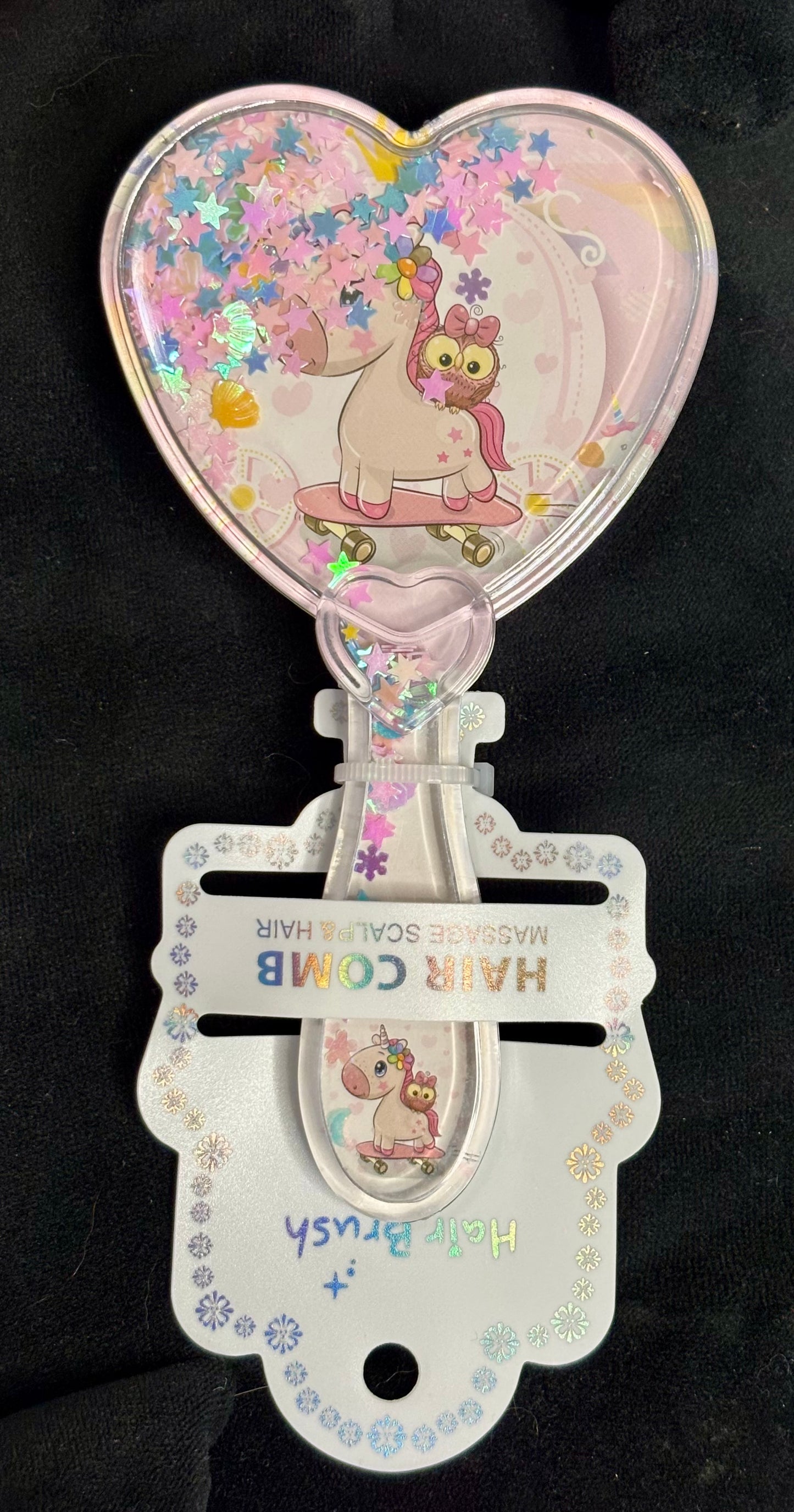 Hair brush with heart-shaped handle featuring a cartoon character on a black background