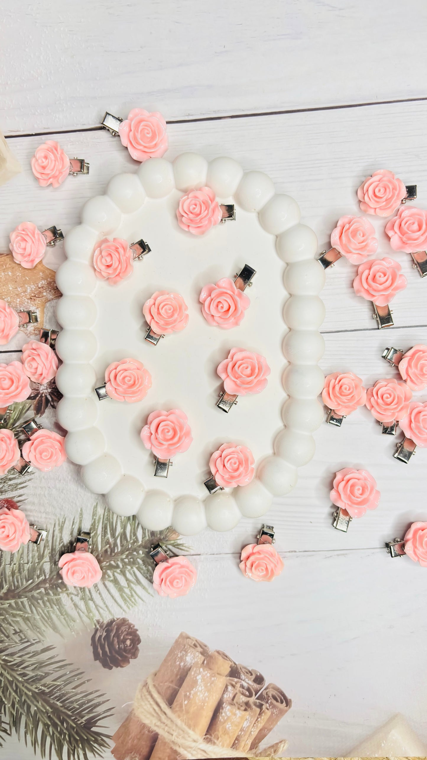 Decorative hair clips with pink flowers and white beads on a light background
