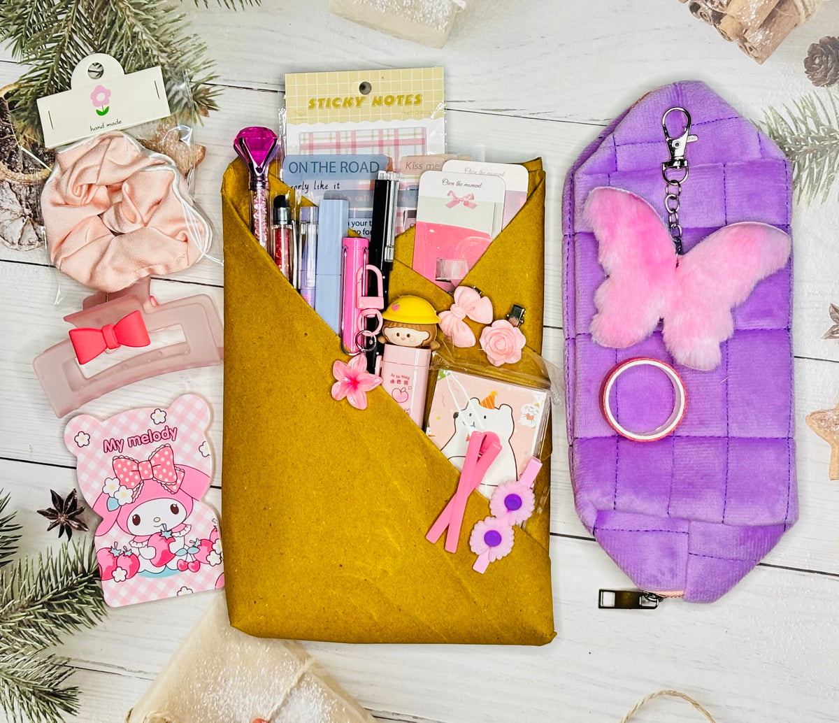 Collection of stationery items including a yellow pouch, pink butterfly keychain, and various small accessories on a white surface.