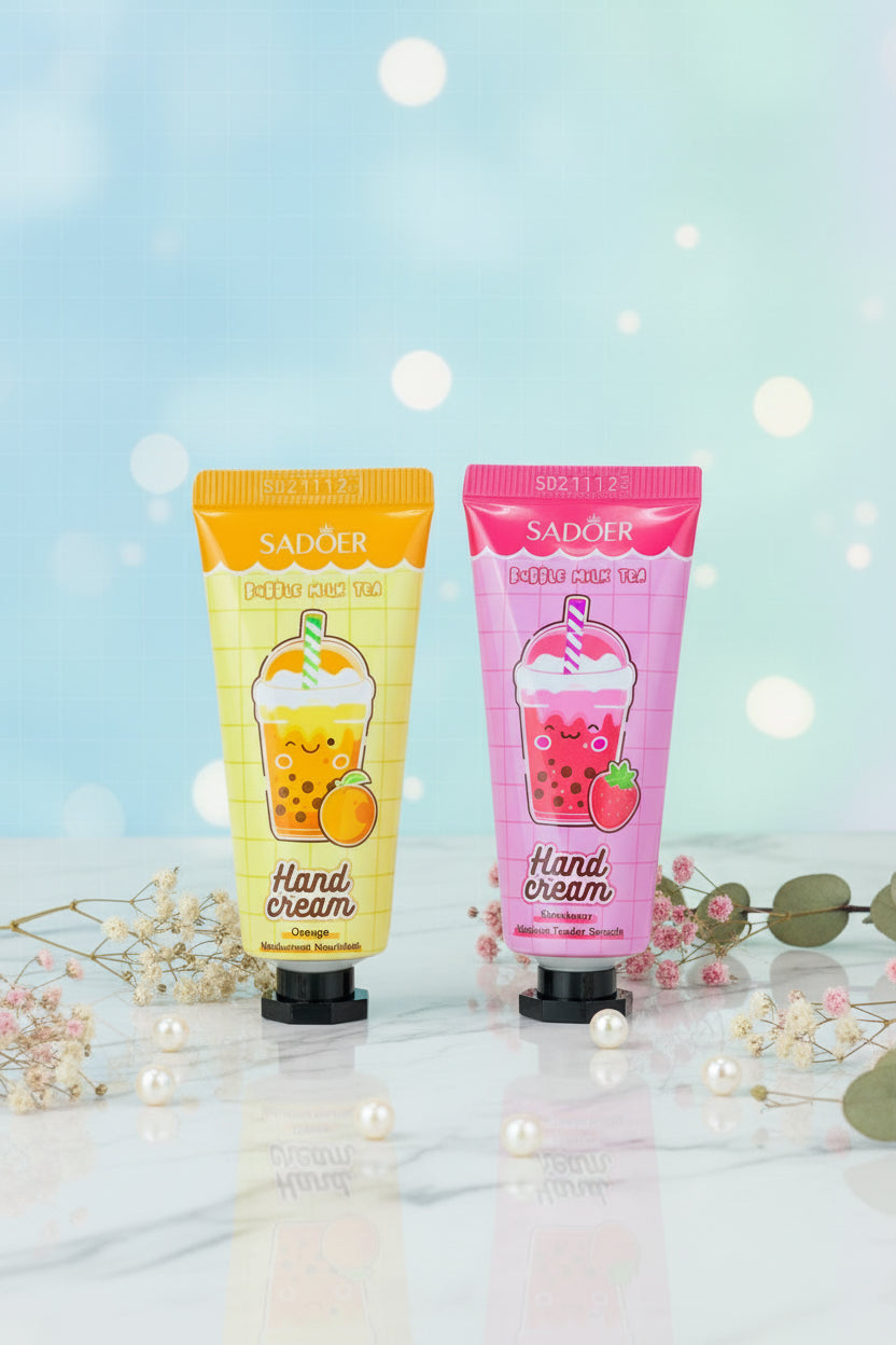 Two Sadoer Bubble Milk Tea Hand Cream tubes held in a hand against a woven wicker background. One tube is yellow with an orange-brown bubble tea illustration, and the other is pink with a purple bubble tea illustration.