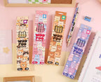 Four boxed 2B pencils with cute animal illustrations in pastel colors, shown on a pink tabletop with a pencil and stationery nearby. Chinese product text and a barcode block appear at the bottom.