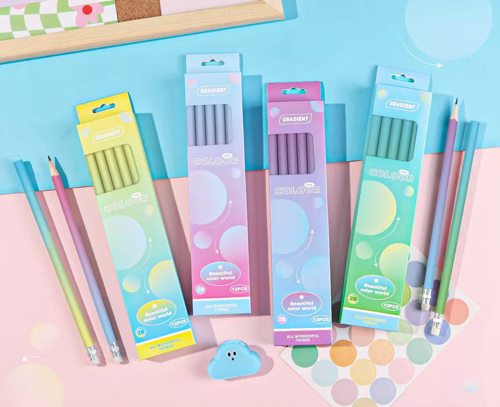 Four pastel-colored 2B pencil boxes arranged on a pink and blue background, with several colored pencils placed beside them. Chinese product text with size, weight, and barcode details appears along the bottom.