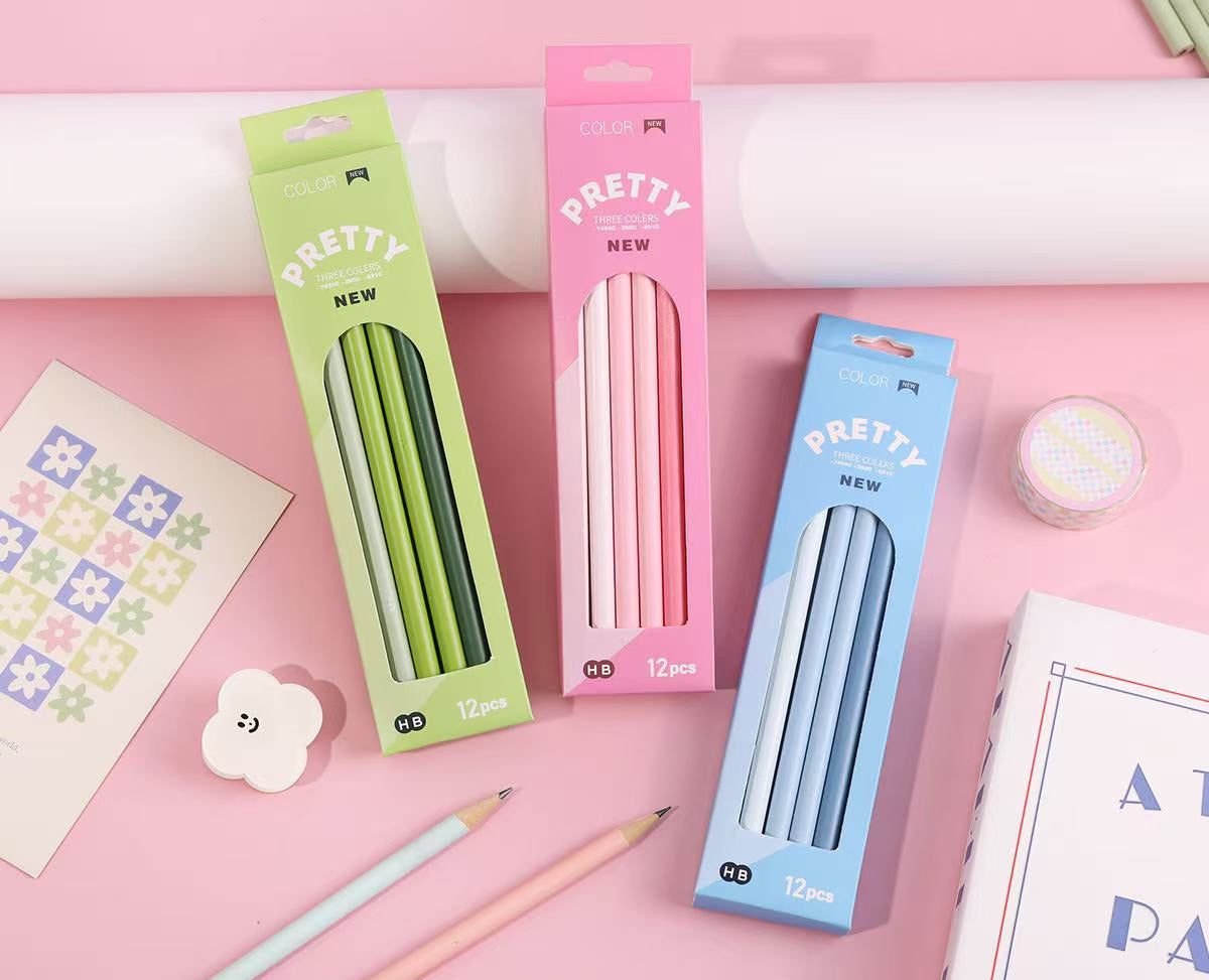 Three boxes of PRETTY NEW 12mm lead pencils in green, pink, and blue, displayed on a pink background with stationery props and Chinese product specifications text at the bottom.