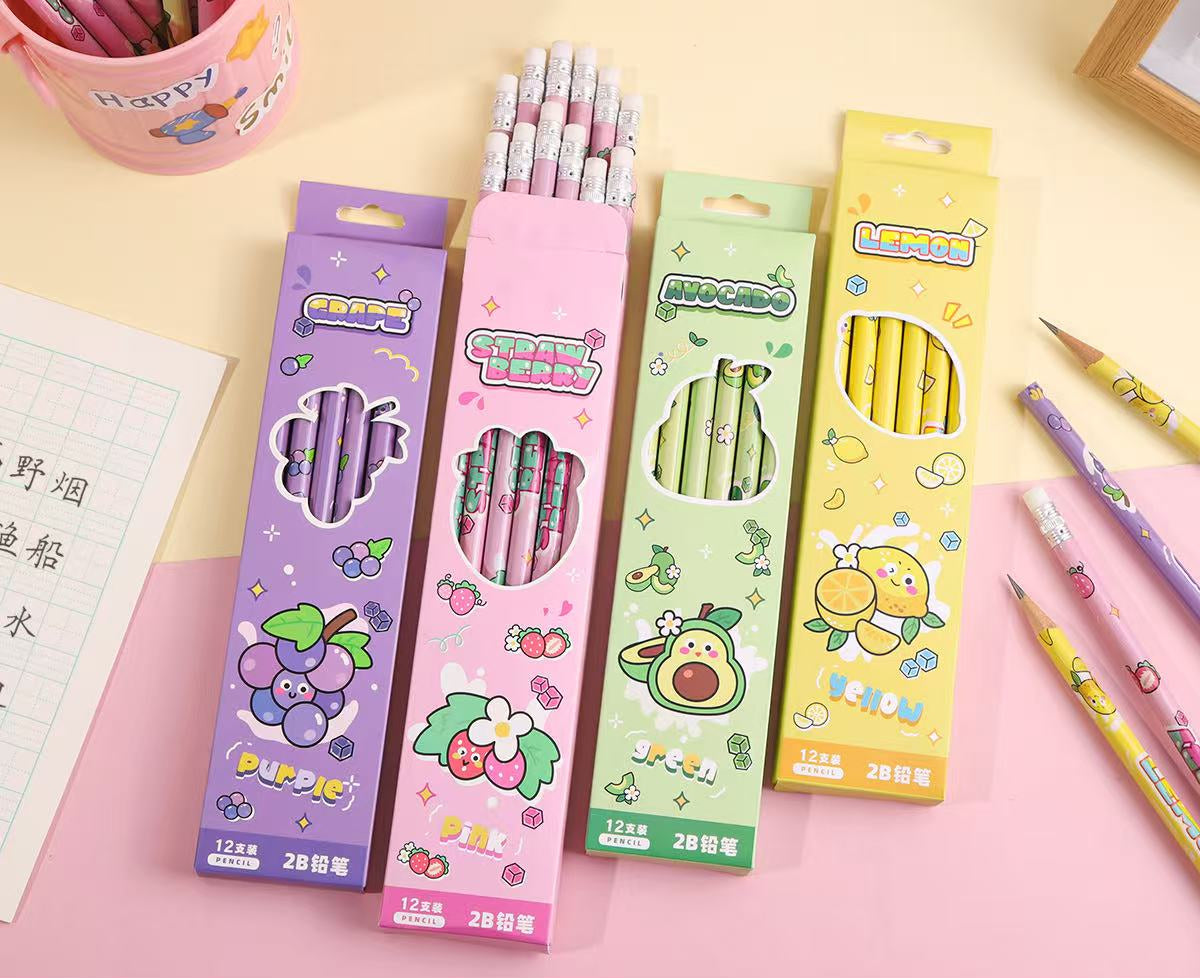 Four pastel-colored pencil boxes with cartoon fruit and animal illustrations, shown on a pink surface with additional pencils around them. Chinese product text and dimensions are printed along the bottom.