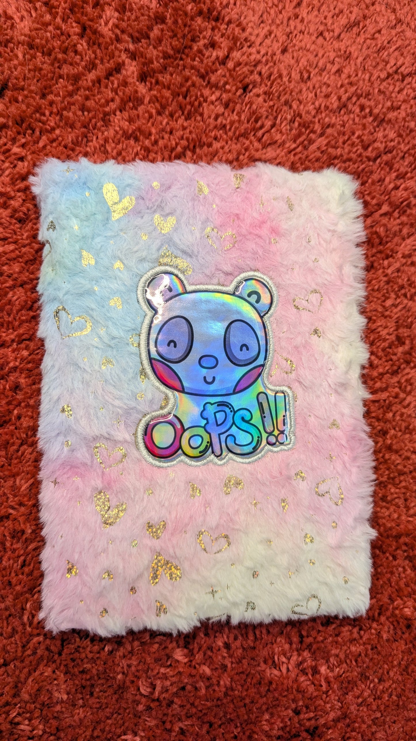 Fluffy pink pillow with a colorful sticker on a red textured background